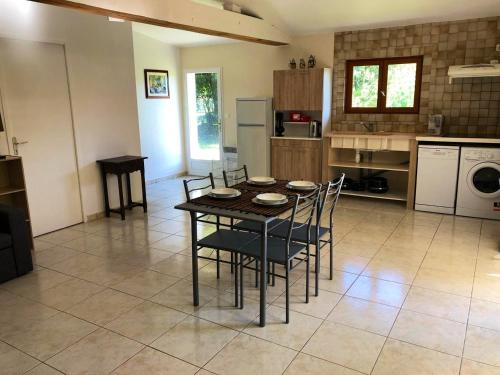 une cuisine avec une table et des chaises dans une pièce dans l'établissement Maison avec Piscine à Pontenx-les-Forges, à Pontenx-les-Forges
