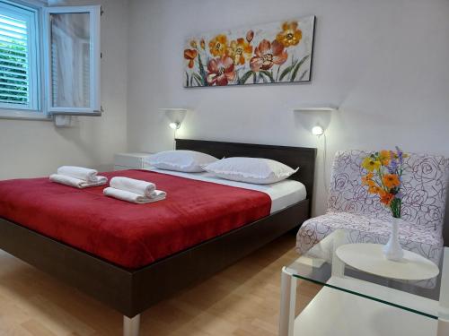 een slaapkamer met een bed en een vaas met bloemen erop bij MG Ravlic Apartments in Makarska