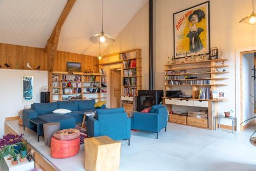 un salon avec des canapés bleus et une télévision dans l'établissement Les Balcons de la Terrasse, à Arsac-en-Velay