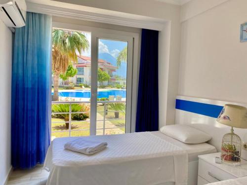 a bedroom with a bed and a large window at Korfez Life Apartments in Fethiye