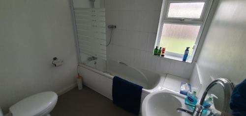 a bathroom with a sink and a toilet and a window at Roomy dog friendly Gosport town house sleeps 6 in Gosport
