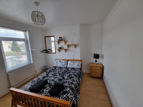 a bedroom with a bed with a black and white comforter at Roomy dog friendly Gosport town house sleeps 6 in Gosport
