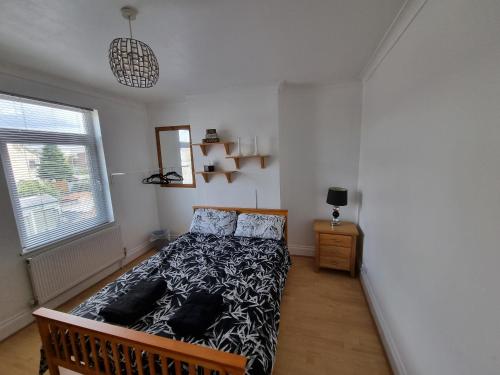 戈斯波特Mayfield , 2 bed slp 6 Roomy dog friendly Gosport town house的卧室里有一张床，床铺是黑白相间的棉被