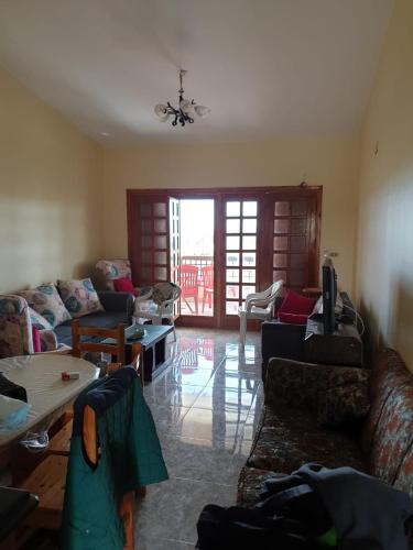uma sala de estar com sofás e uma sala de estar com uma mesa em شاليهات للايجار بمارينا 4،5،6، em El Alamein