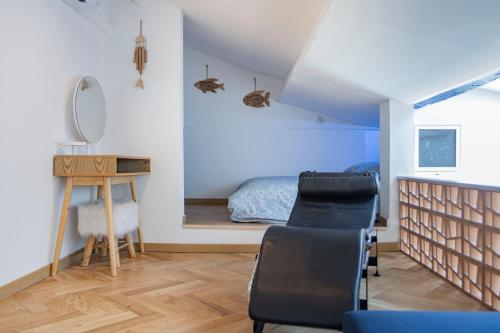 a bedroom with a bed and a desk and chairs at Appart Port Cassis Village Parking in Cassis