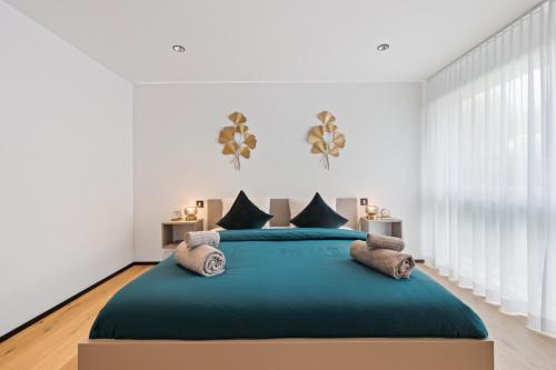 a bedroom with a large bed with blue sheets and pillows at The R Apartment Zugerberg - EV Wallbox - Terrasse in Geroldswil