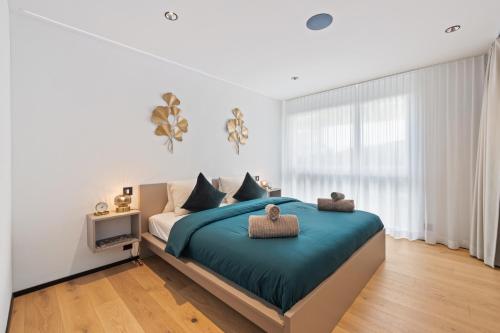 a bedroom with a large bed with a blue blanket at The R Apartment Zugerberg - EV Wallbox - Terrasse in Geroldswil
