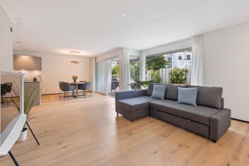 a living room with a couch and a table at The R Apartment Zugerberg - EV Wallbox - Terrasse in Geroldswil