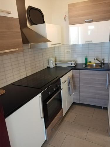 a kitchen with black counter tops and a sink at COSY APARTMENT FILIP IN THE HISTORICAL OLD TOWN in Koper