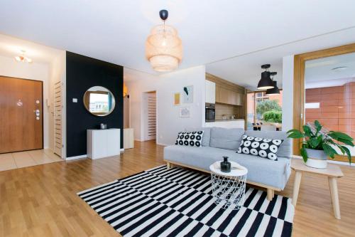 ein Wohnzimmer mit einem blauen Sofa und einem Teppich in der Unterkunft City Center Apartments SPA & Wellness in Danzig