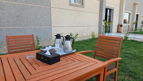a wooden table with two coffee makers on top of it at رؤوم إن للشقق الفندقية-Raoum Inn Hotel Apartments-Buraydah in Buraydah