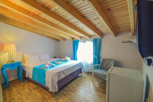 um quarto com uma cama, uma cadeira e uma janela em Bedirhan Konak Otel em Alacati