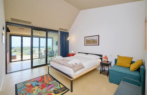 馬里納－迪拉古薩的住宿－Petrantica Resort，一间卧室配有一张特大号床和一张蓝色的沙发