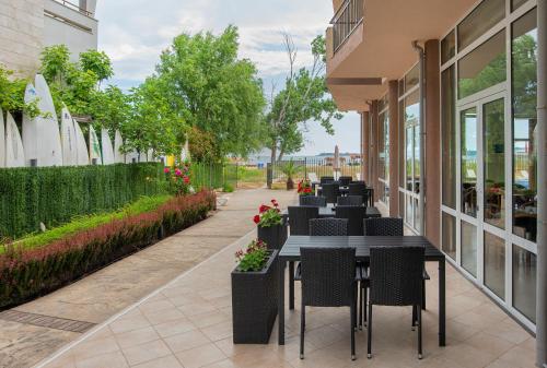 a row of tables and chairs on a sidewalk at Aparthotel Royal Marina Beach in Chernomorets