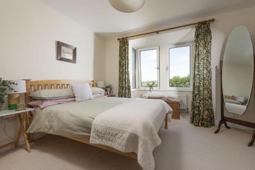 a bedroom with a bed and a window at Treen House, Porthcurno in Porthcurno