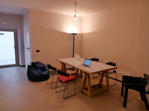 Habitación con mesa, sillas y ordenador portátil. en Casa della Rosa Dolomites experience en Vigo di Cadore
