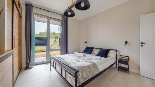 a bedroom with a bed and a large window at Apartamenty Sun & Snow Par La Mer in Niechorze