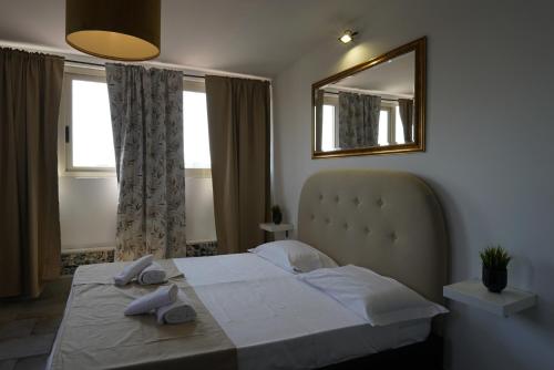 a bedroom with a bed and a mirror and windows at Airport suite in Catania