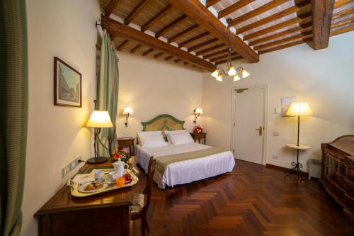 a bedroom with a bed and a table in a room at Hotel Fortuna in Perugia