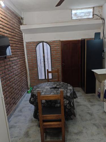 a dining room with a table and chairs and a brick wall at Departamento Zona Centro Ubicado A 1 Cuadra De La Terminal De Ómnibus De Catamarca in San Fernando del Valle de Catamarca