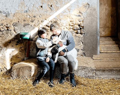 a man and two children sitting on a bench at Joy Tiny House Perche in Madeleine