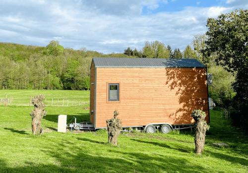 a tiny house on a trailer in a field at Joy Tiny House Perche in Madeleine