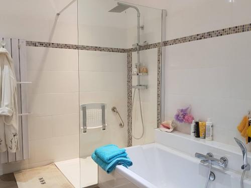 La salle de bains blanche est pourvue d'une douche et d'une baignoire. dans l'établissement Haut Standing, à Ajaccio