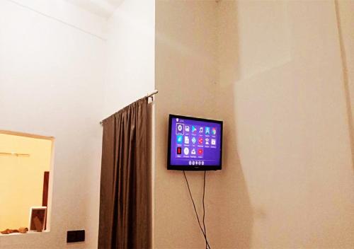 a tv hanging on a wall in a room at Welcome to a small apartment near Ras El Lefa Beach in Safi