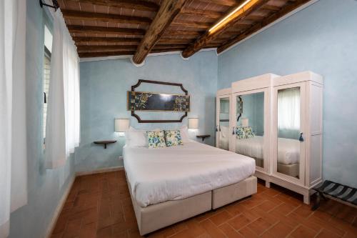 ein Schlafzimmer mit einem weißen Bett und blauen Wänden in der Unterkunft BORGO A MONTI di Sotto in Monti di Sotto