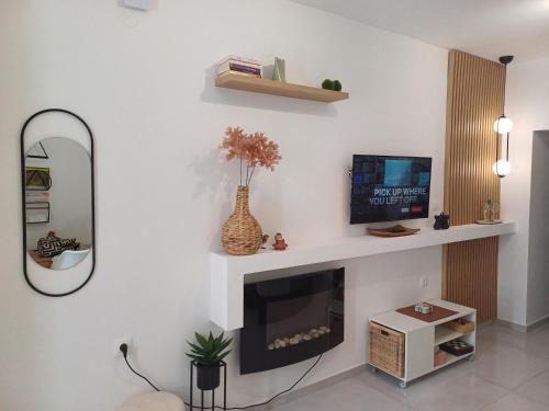 a living room with a tv and a mirror at BRIO luxurious urban stay in Heraklio,WiFi,ΑC in Heraklio