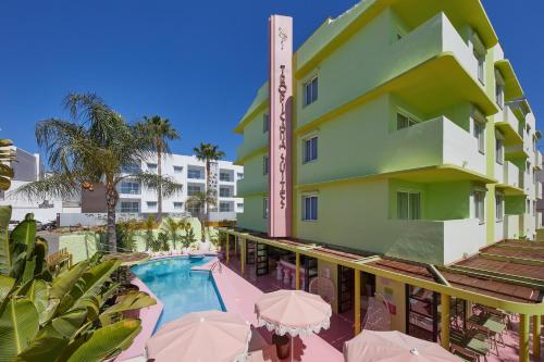 - Vistas a un hotel con piscina y sombrillas en Tropicana Ibiza Suites - Adults Only en Playa d'en Bossa