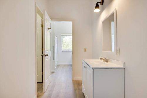 La salle de bains blanche est pourvue d'un lavabo et d'un miroir. dans l'établissement Spacious 6 Bdrm w/ Private Indoor Pool + VIEWS, à Narrowsburg