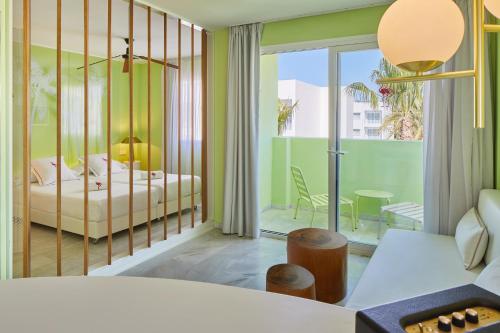 um quarto com uma cama e uma varanda em Tropicana Ibiza Suites - Adults Only em Playa d'en Bossa