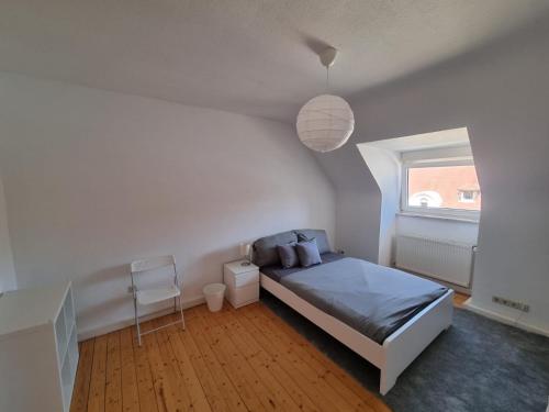 a white bedroom with a bed and a window at Süße Marie 2 in Karlsruhe