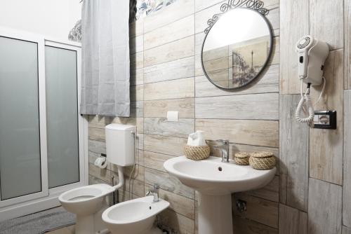 a bathroom with a sink and a toilet and a mirror at Airport suite in Catania