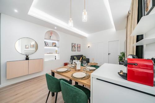 a kitchen and dining room with a wooden table and green chairs at 2mn Monaco - Luxueux appartement rénové - AS in Beausoleil