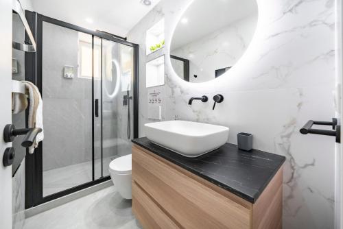 a white bathroom with a sink and a shower at 2mn Monaco - Luxueux appartement rénové - AS in Beausoleil