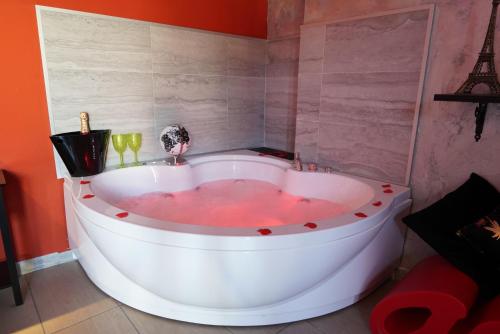a white bath tub in a bathroom with the eiffel tower at Airport suite in Catania