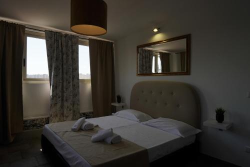 a bedroom with a bed and a mirror and windows at Airport suite in Catania