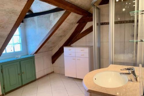 uma casa de banho com um lavatório e uma janela em Les Longères de Belle Vue - à 30' du Parc de Loisir du PAL em Bourbon-Lancy