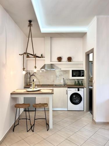 a kitchen with a table and two stools in it at Aventora Apartments in Lygia