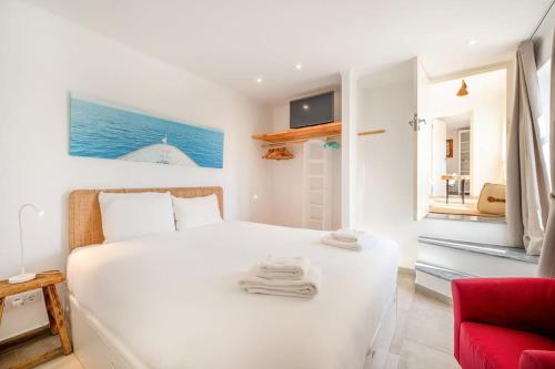 una camera bianca con un letto bianco e una sedia rossa di GuestReady - A special place near the beaches a Colares