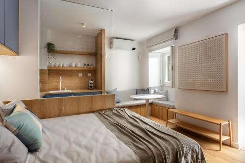 a bedroom with a bed and a sink and a table at Oak Studio in Setúbal