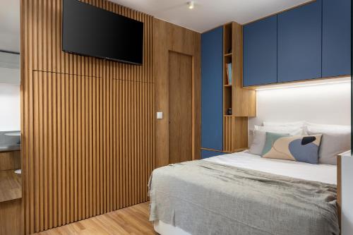 a bedroom with a bed and a television on a wall at Oak Studio in Setúbal