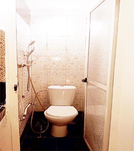 a small bathroom with a toilet and a shower at Welcome to a small apartment near Ras El Lefa Beach in Safi