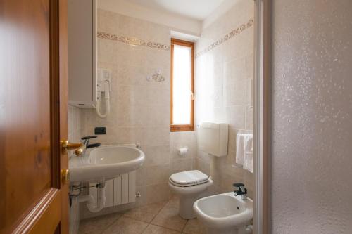 a bathroom with a toilet and a sink at Max Meublè in Castione della Presolana