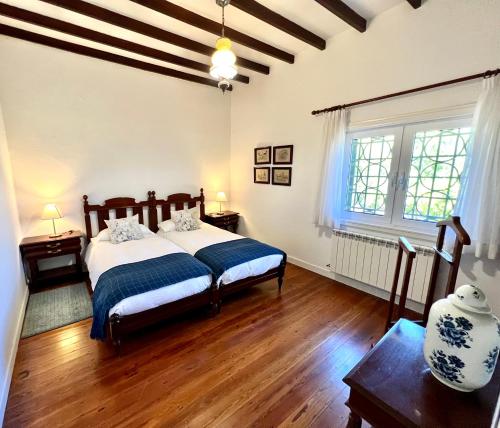 een slaapkamer met een bed, houten vloeren en een raam bij Casa La Veguetilla en San Mateo in Vega de San Mateo