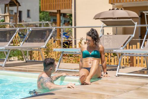 un uomo e una donna in una piscina di Residence Toli a Ledro