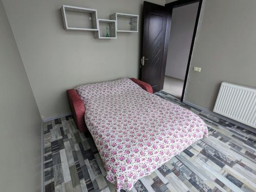 a bedroom with a bed with a pink blanket on it at Гостевой дом с красивой панорамой на город in Batumi