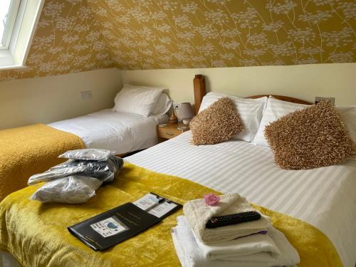 a bedroom with two beds with towels and a book on the bed at Aquarius B&B in Newquay